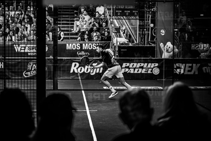 Zwart-witfoto van een speler langs het net