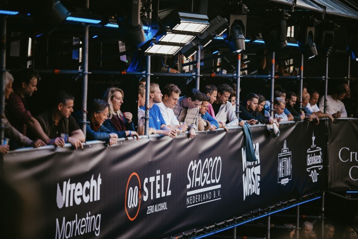 Publiek leunt over de tribunerailing